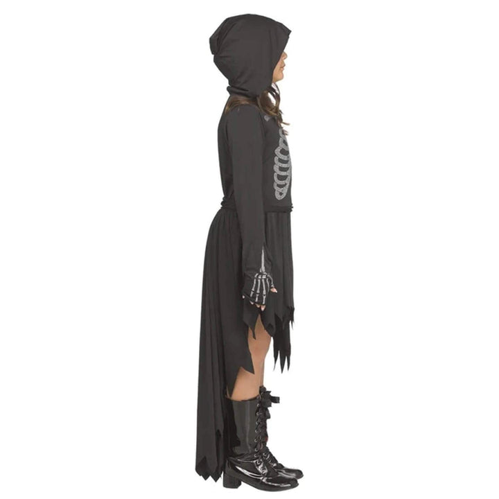 Profile view of a child wearing a hooded dress with black boots and skeleton graphic