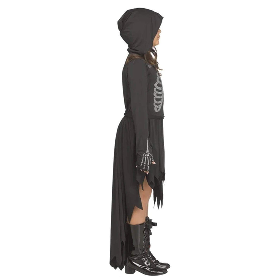 Profile view of a child wearing a hooded dress with black boots and skeleton graphic