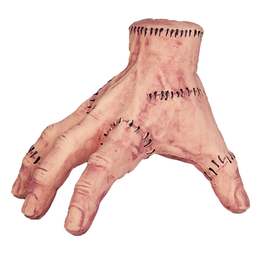 A severed-looking hand prop with stitched seams and a pale flesh-toned color, isolated on a white background.