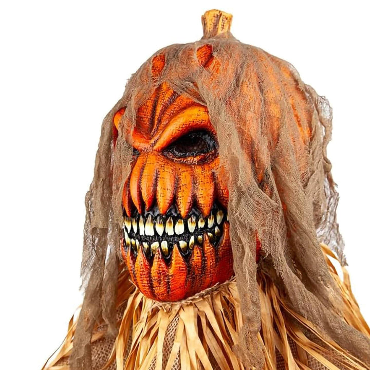 A scary Halloween pumpkin mask with a stitched-looking black eye, sharp teeth, and brown gauzy hair, shown against a plain white background.