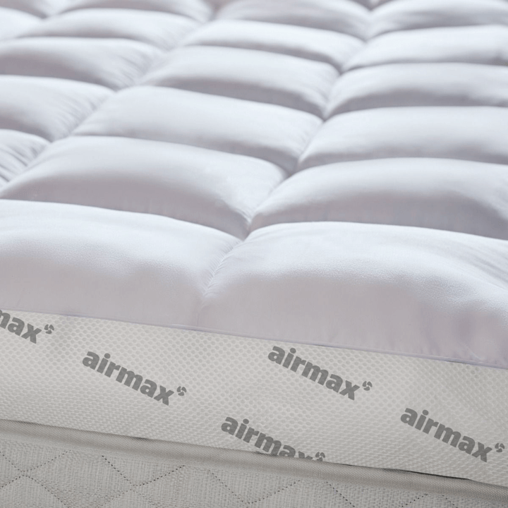 Close-up of a mattress with 'airmax' branding on a white background