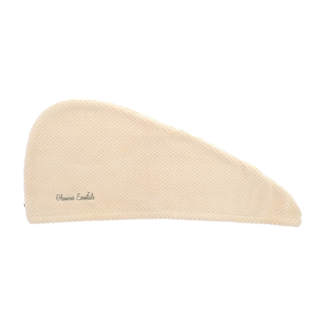 Cream hair drying turban with waffle texture laid flat on a white background