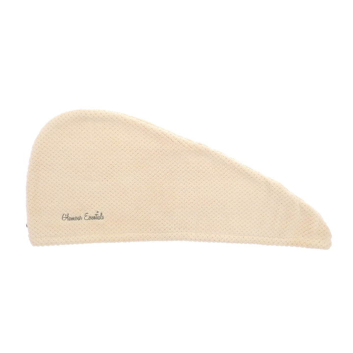 Cream hair drying turban with waffle texture laid flat on a white background