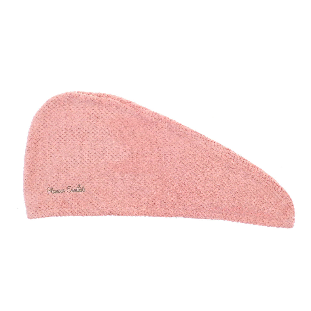 Pink hair drying turban with waffle texture laid flat on a white background