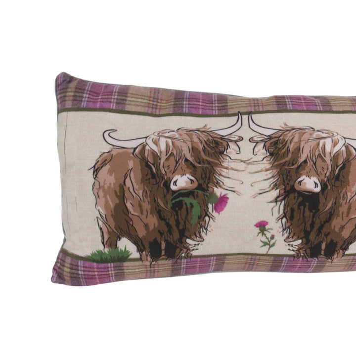 close up of draught excluder featuring highland cow with thistle in it's mouth on white background