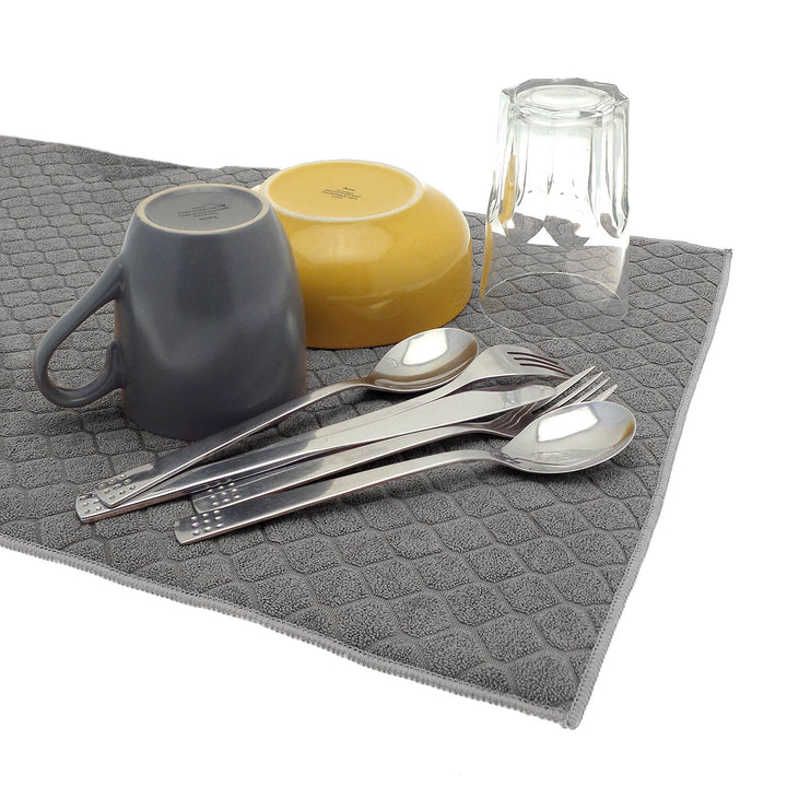 Cutlery and dishes on a grey dish drying mat