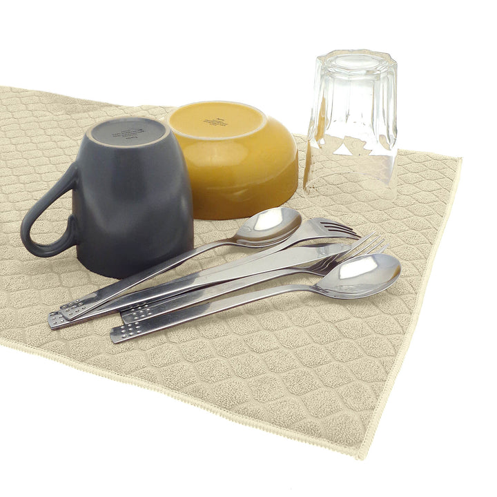 Cutlery drinking glass mug and bowl on a beige colour dish drying mat