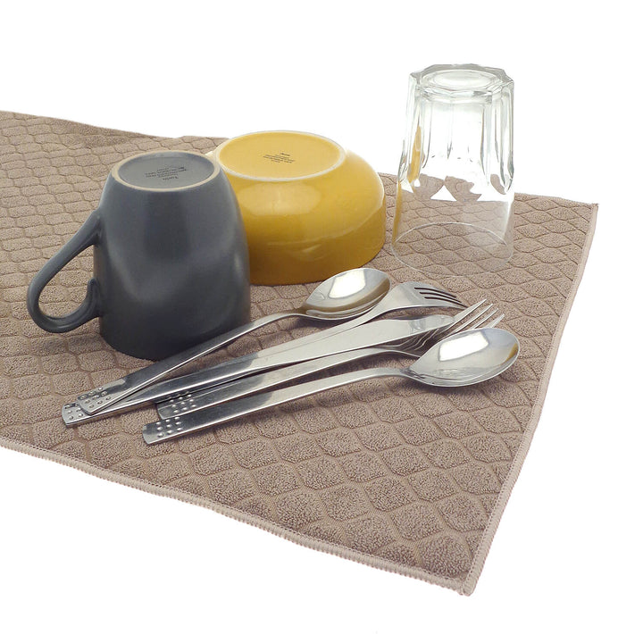 Cutlery drinking glass mug and bowl on a natural colour dish drying mat
