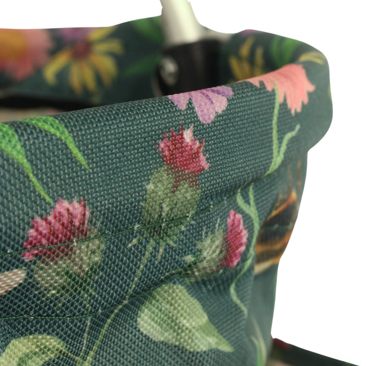Floral-patterned fabric with pink flowers and green leaves on a dark background