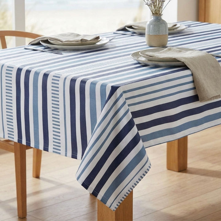Table with a blue and white striped tablecloth, plates, and napkins.