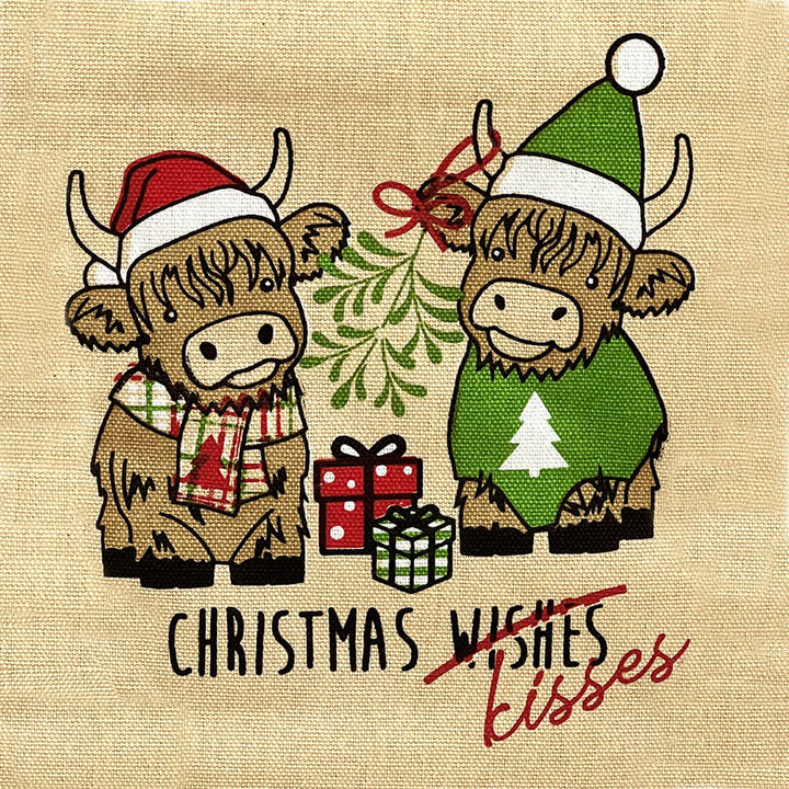 Detail of two Christmas Highland cows on beige fabric with Christmas kisses text