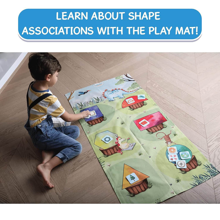 Boy playing on the floor with a large play mat with shape matching