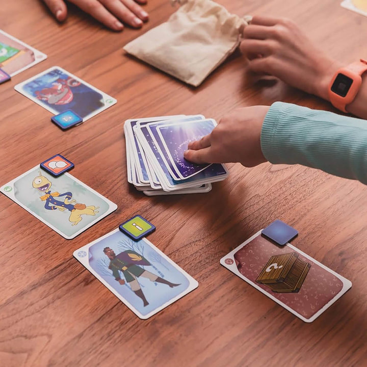 Card game in progress on a wooden table with colorful cards and hands interacting.