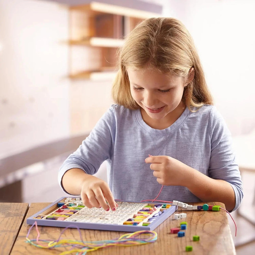 Girl creating a necklace with a wooden bead set
