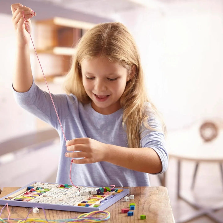 Girls making a necklace with alphabet beads