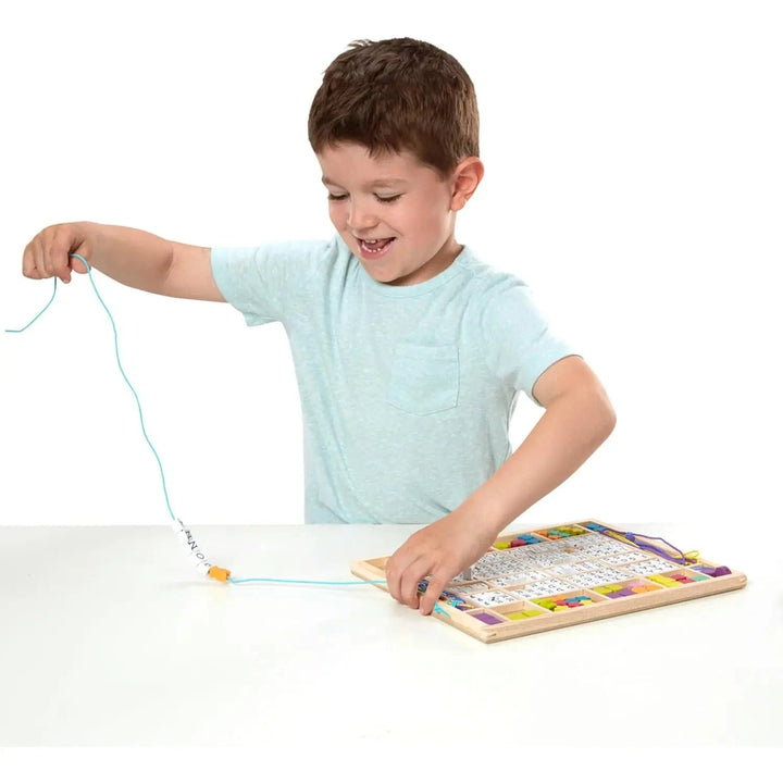 Boy creating arts and crafts beaded alphabet necklace