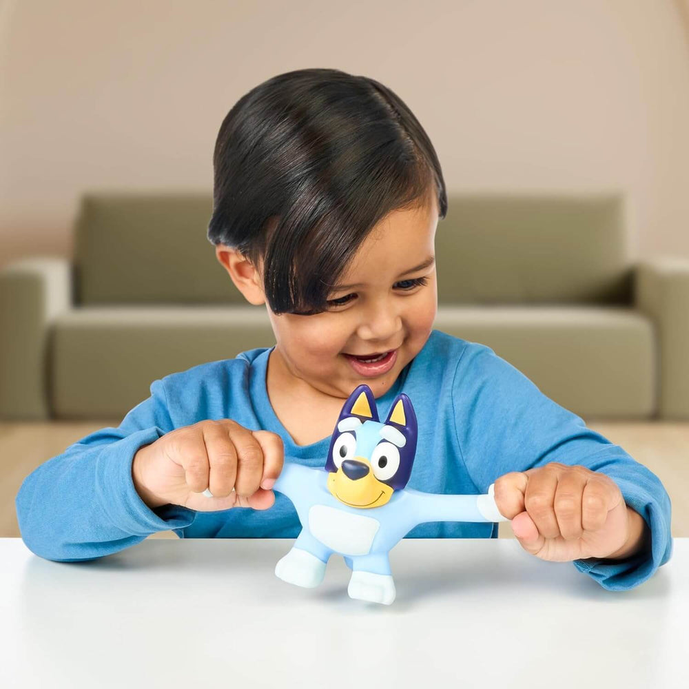 Child stretching the arms of a stretch Bluey action figure