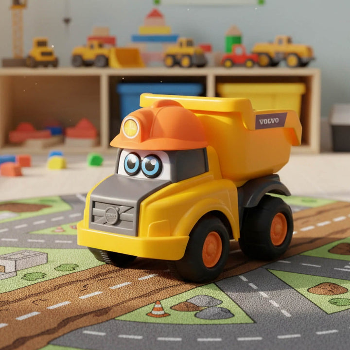 A yellow and orange toy dump truck with cartoon eyes and a Volvo badge, placed on a road play mat in a children&