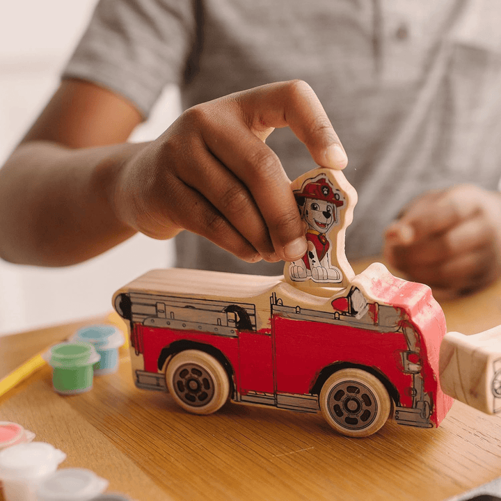 young boy adds paw patrol dog into painted fire engine
