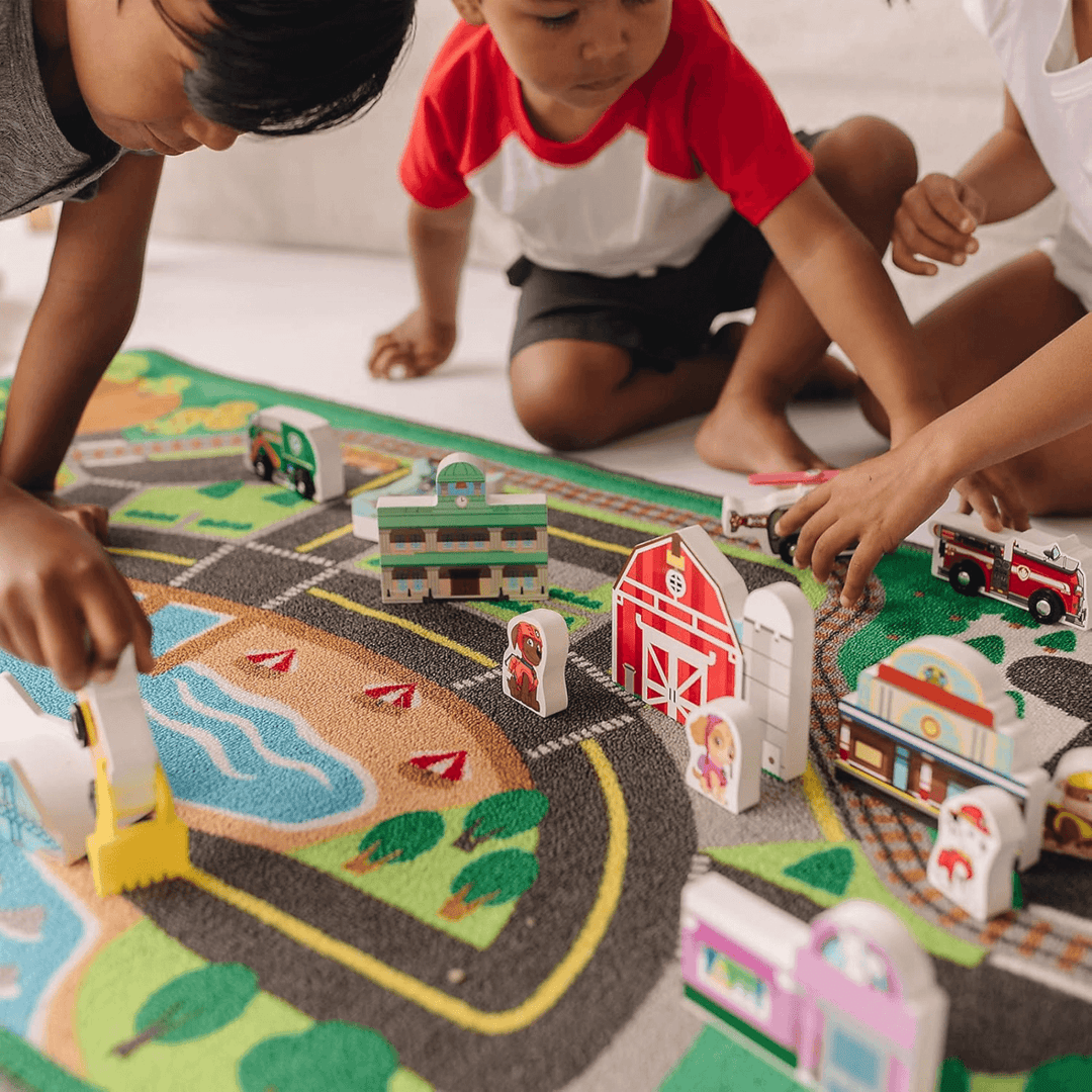 group of young boys move wooden play block n the activity rug 