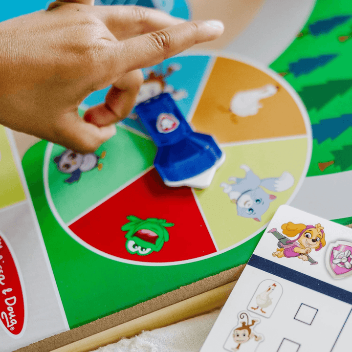 little girls hand spins the wheel on the activity board