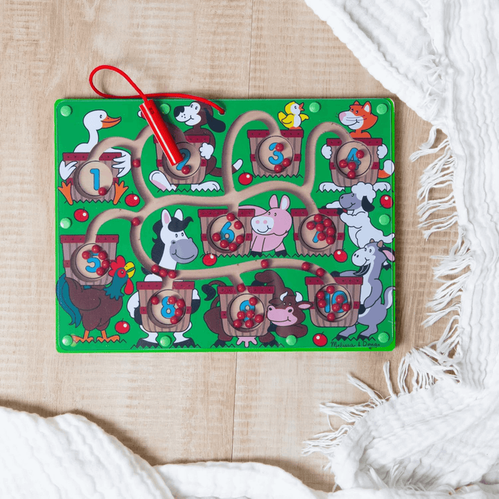 green farm animal puzzle maze on wooden floor in bedroom with blanket to the side