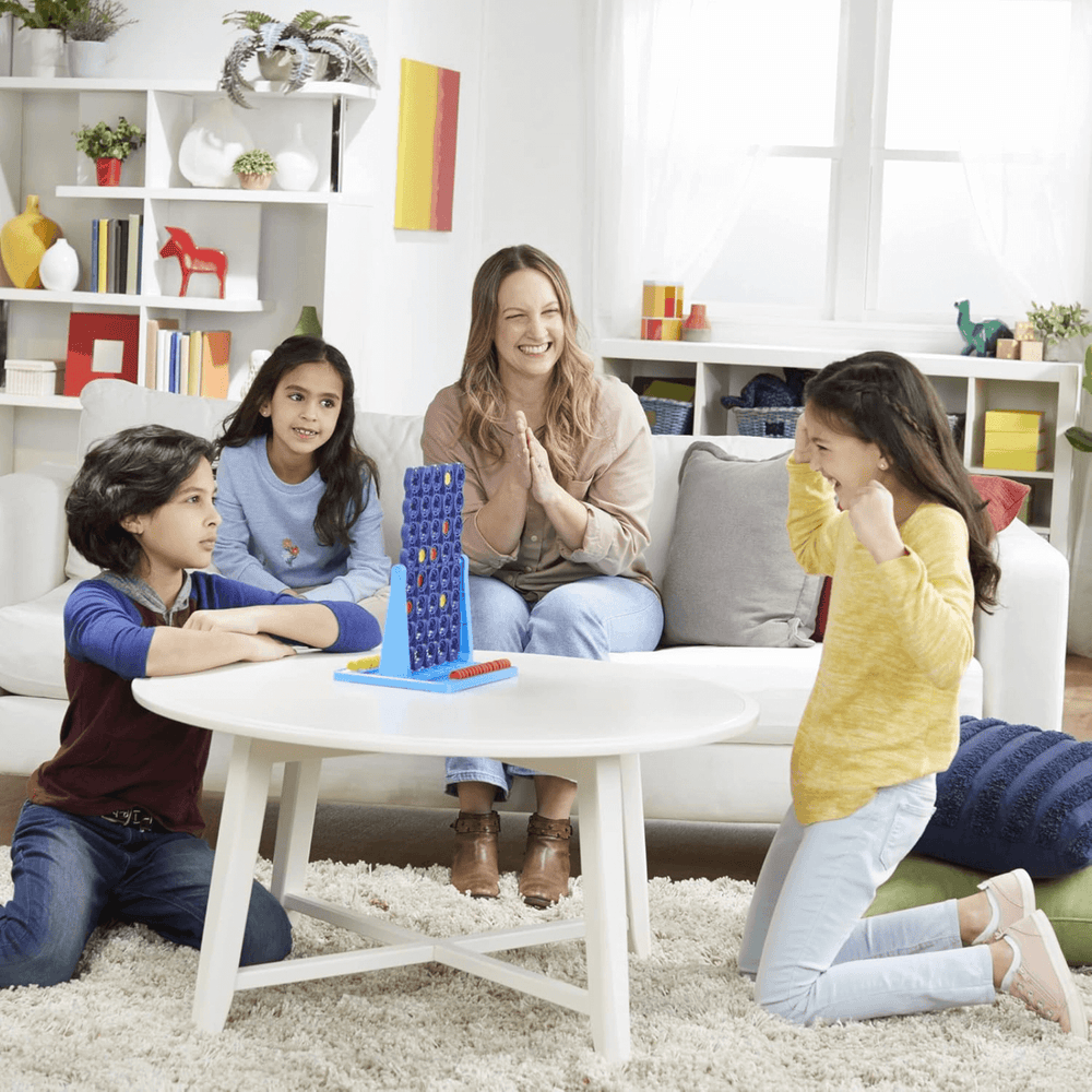 family play at home with connect 4 spin, 2 kids play and mum and daughter watch on smiling