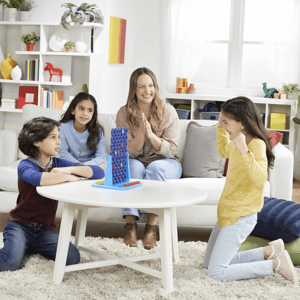 family play at home with connect 4 spin, 2 kids play and mum and daughter watch on smiling