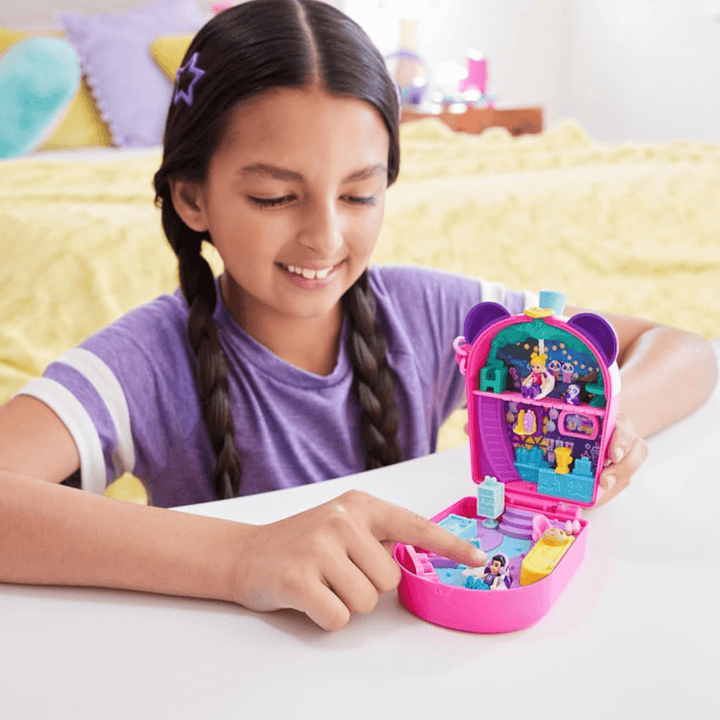little girls smiles in he bedroom as she plays with her panda bubble tea playset with a micro doll wearing headphone accessories sitting in chair