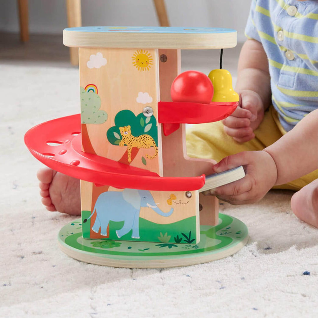 Child playing with a colourful treehouse ball run wooden toy 