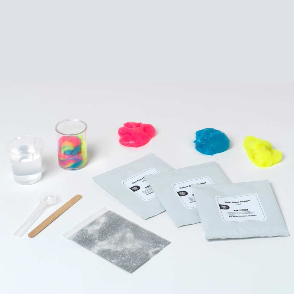 Colorful slime packets with a glass of water and spoon on a white background