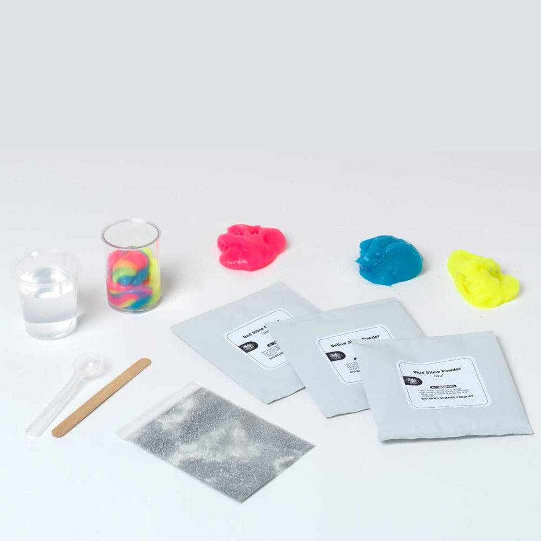 Colorful slime packets with a glass of water and spoon on a white background