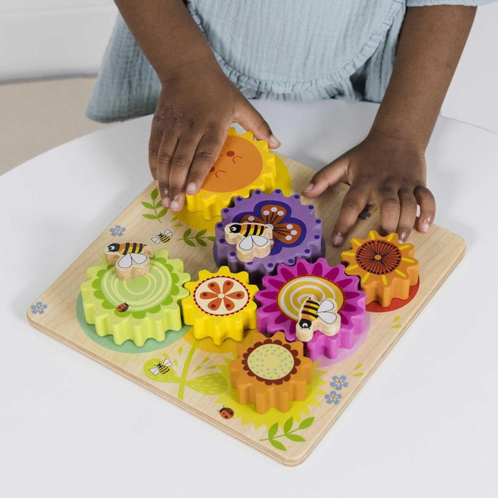 Child playing with a colourful wooden puzzle on a white surface