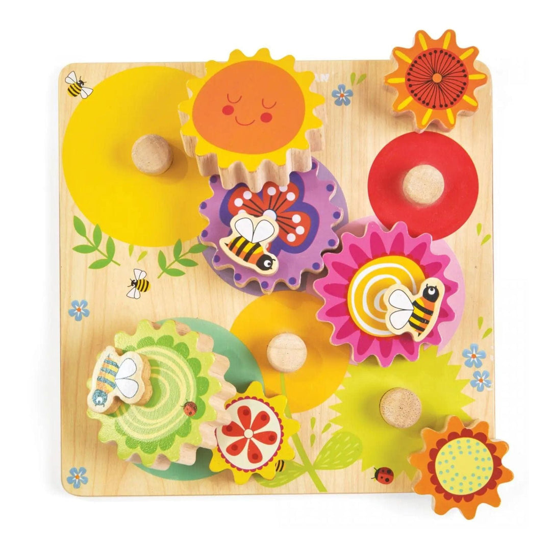 Wooden puzzle with colourful gears featuring flowers, bees, and the sun on a wooden board.