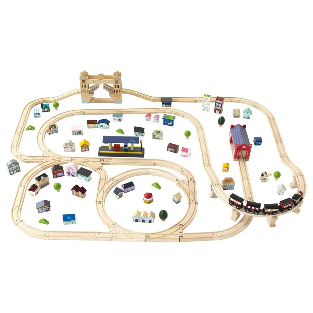 Wooden toy train set with tracks and small buildings on a white background