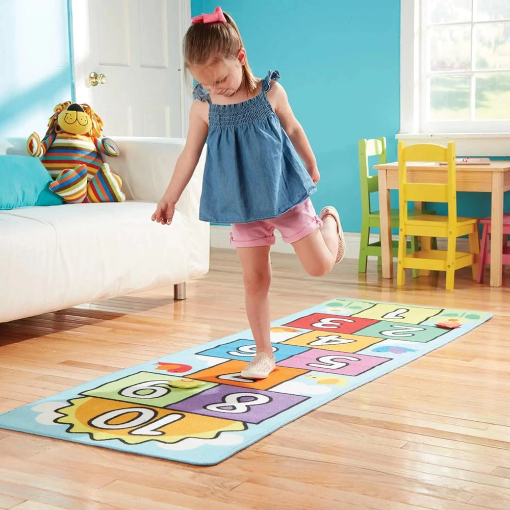 Girl playing on a Hopscotch rug in a child's bedroom
