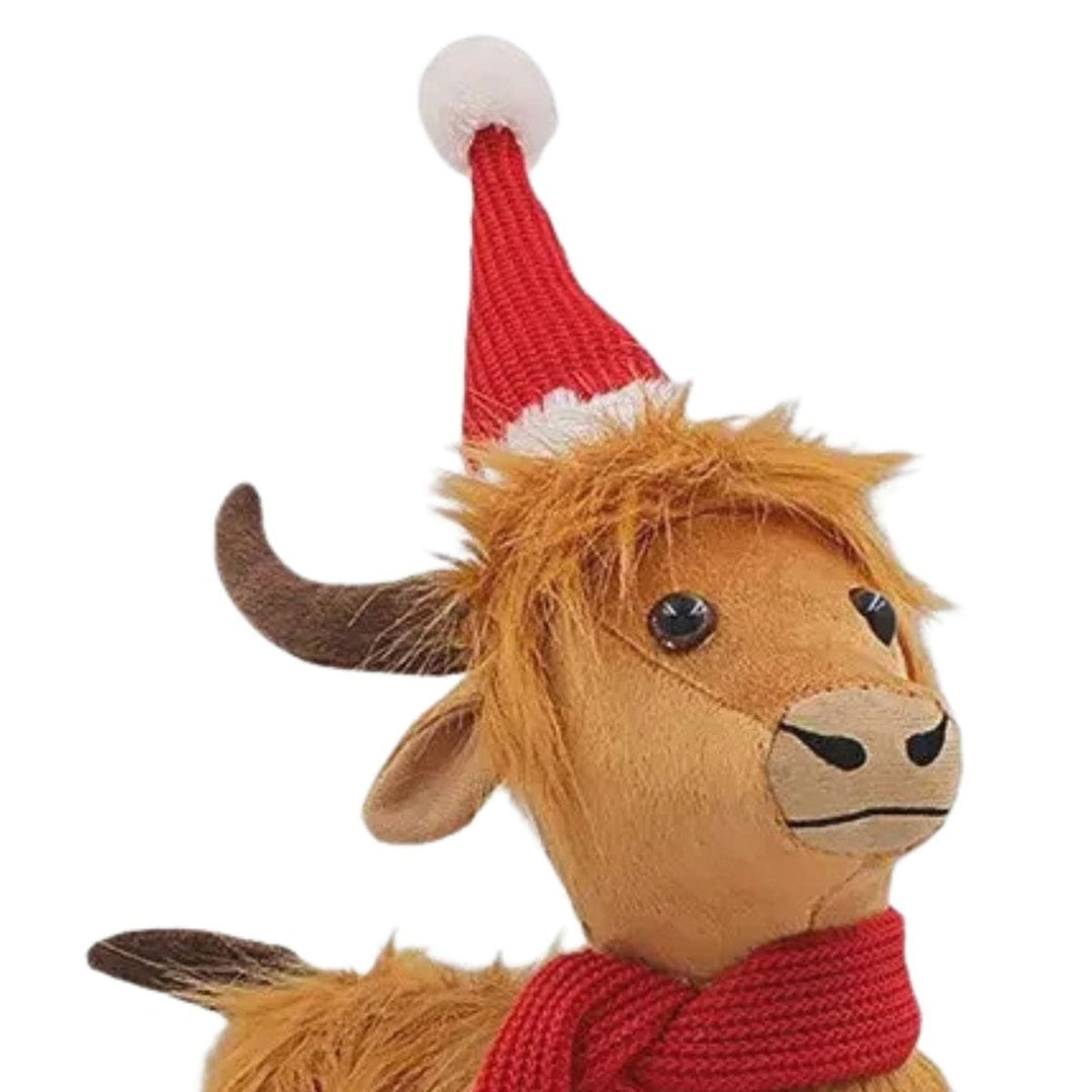 close up of highland cow figure wearing a knitted santa hat with plush horns and beaded eyes