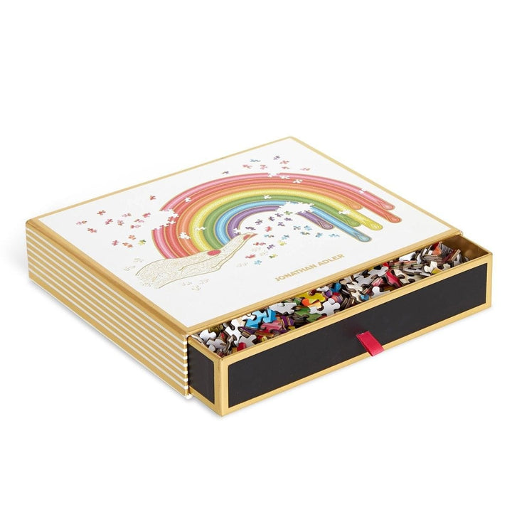 side view of jigsaw puzzle box featuring pull out draewer with red ribbon tab, striped gold and white sides