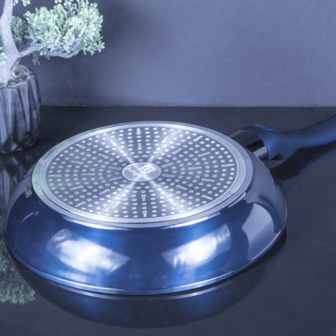 Blue frying pan with a perforated base on a dark surface