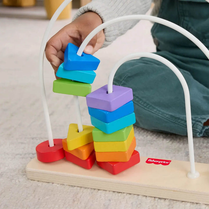 Child playing with a colourful wooden shape counting toy, with a Fisher-Price logo visible.