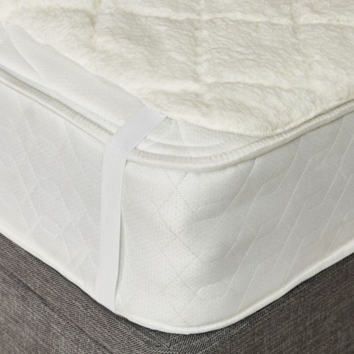 White mattress protector on a bed with a textured surface