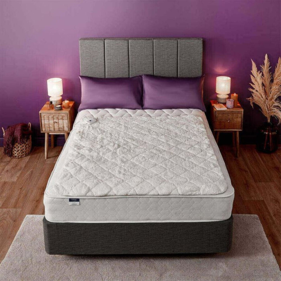 Mattress on a bed with purple walls and decor