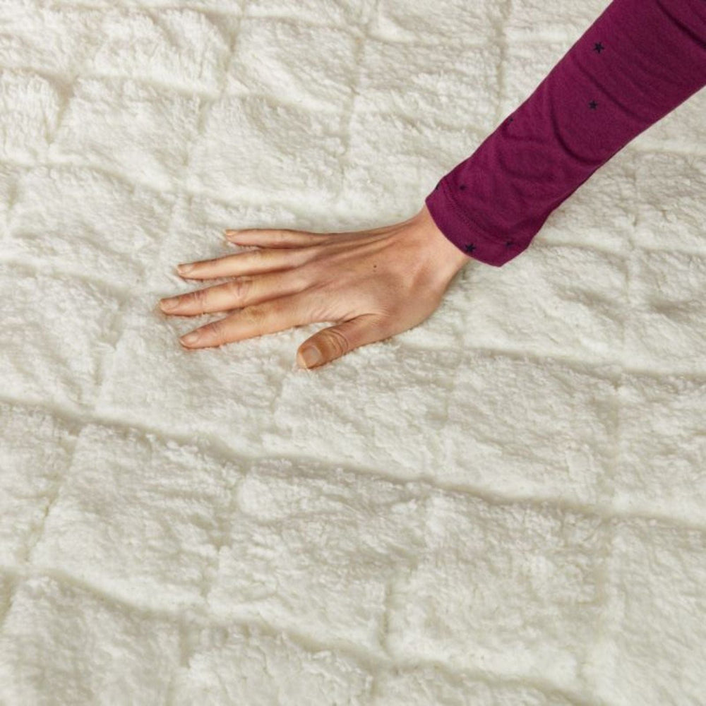 Hand touching a textured white fabric surface