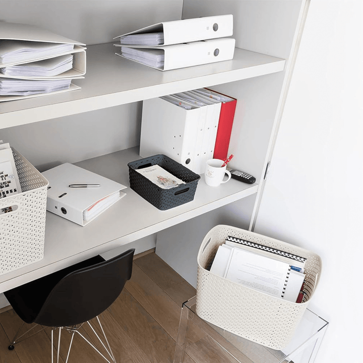 storage basket filled with cards in office shelf beside binder of files and black office chair