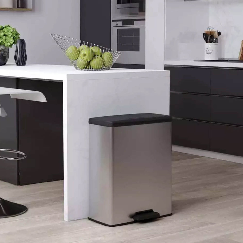a silver and grey pedal bin in a kitchen with apples in a basket