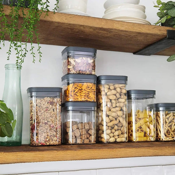 Pasta, nuts and cereal in food storage containers on a wooden shelf