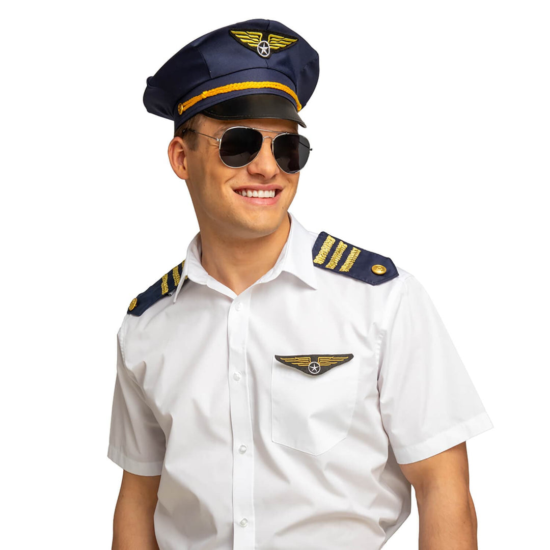 Man wearing a pilot uniform with a cap and sunglasses on a white background