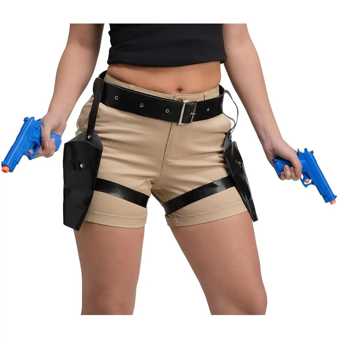 Model wearing shorts, a black belt with twin gun holsters, holding blue plastic hand guns, for Lara Croft fancy dress costumes