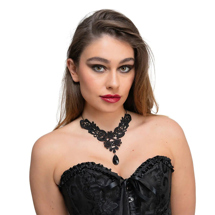 Woman wearing a black bodice and black lace necklace with large black teardrop gemstone