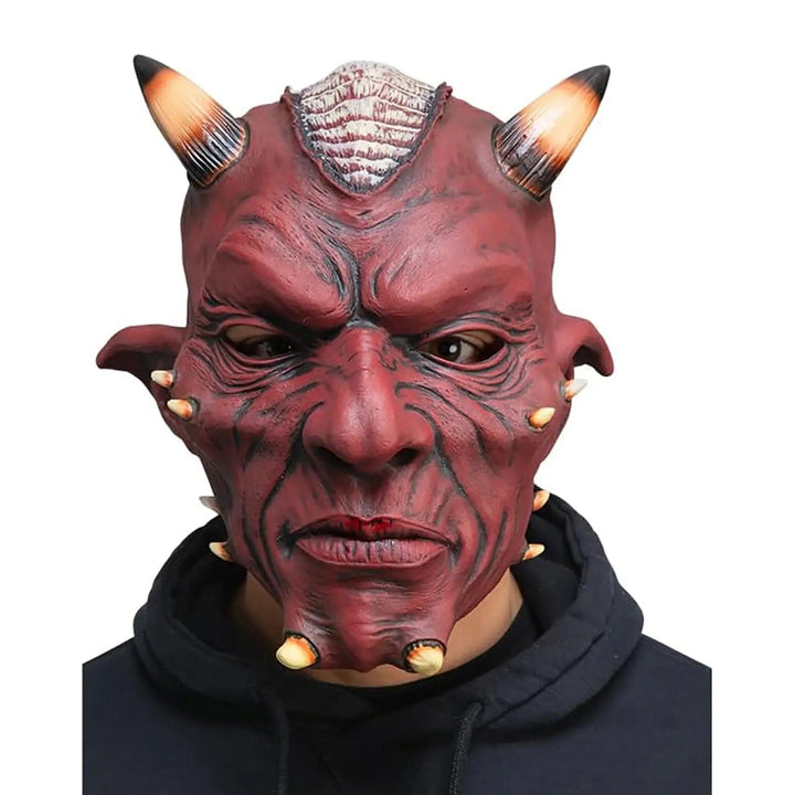 Model wearing a red devil mask with horns and pointed ears for fancy dress costumes